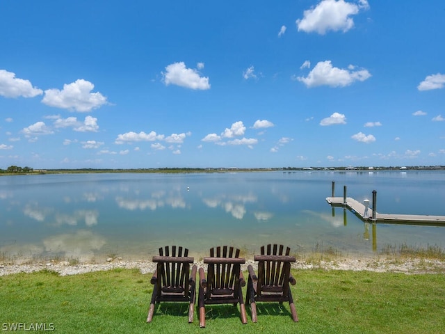 view of dock featuring a water view and a yard