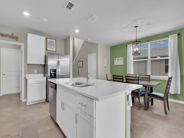 17941 Saddle Rd, Punta Gorda, FL 33982 - kitchen with light countertops, stainless steel appliances, a sink, white cabinetry, and a kitchen island with sink