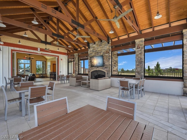 wooden terrace with a patio, an outdoor living space with a fireplace, and ceiling fan