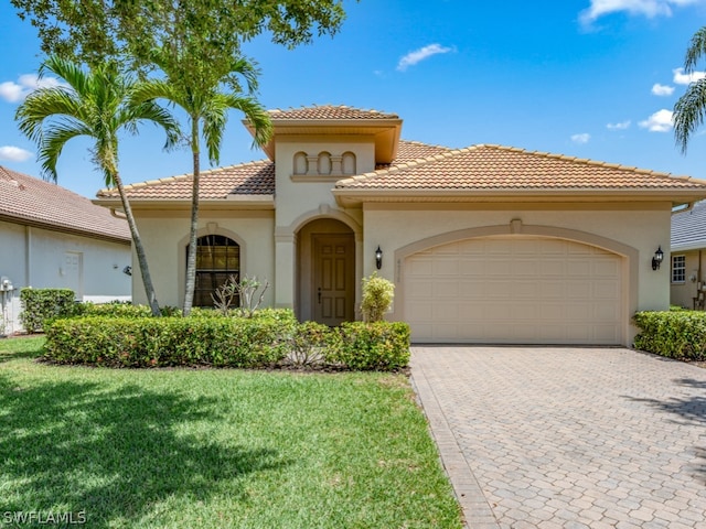 mediterranean / spanish-style home featuring a garage and a front yard