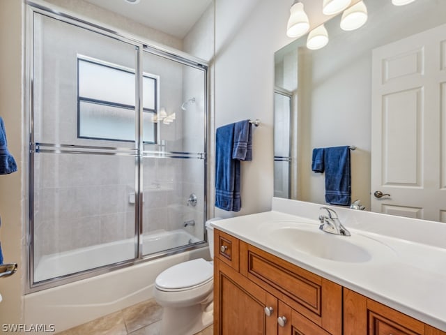 full bathroom featuring tile patterned flooring, bath / shower combo with glass door, toilet, and vanity