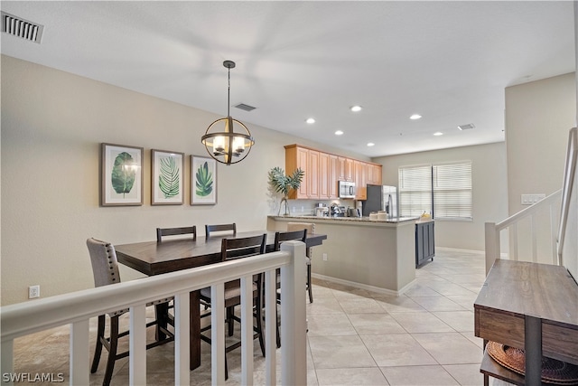 tiled dining space featuring a chandelier