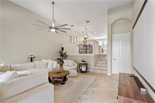 living room featuring lofted ceiling, light tile floors, and ceiling fan with notable chandelier