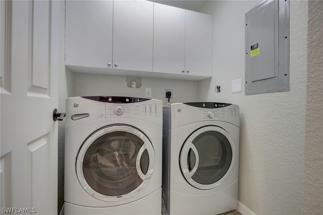 laundry area featuring a textured wall, independent washer and dryer, electric panel, and cabinet space