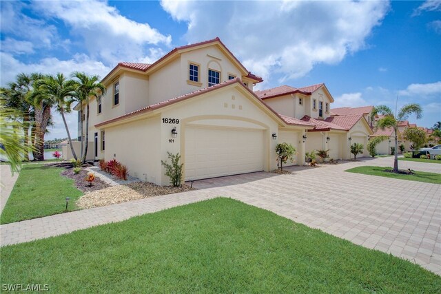 mediterranean / spanish-style home featuring a front yard and a garage