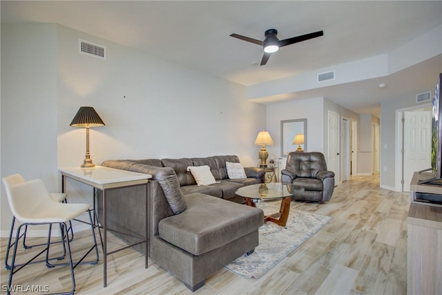 living area with a ceiling fan, light wood-type flooring, and visible vents