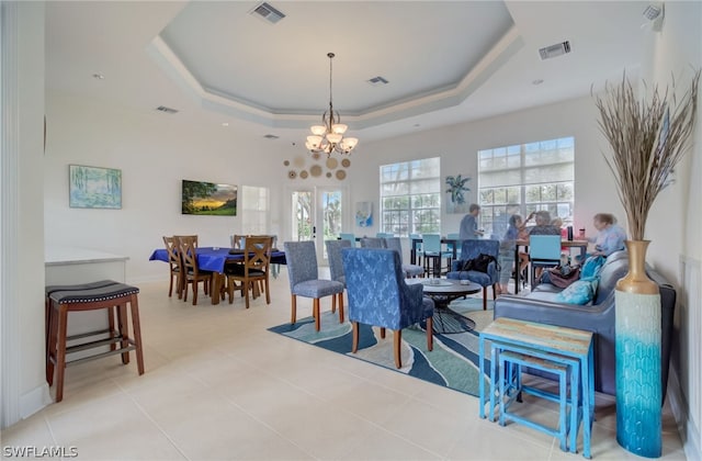 dining room featuring a raised ceiling, visible vents, and an inviting chandelier