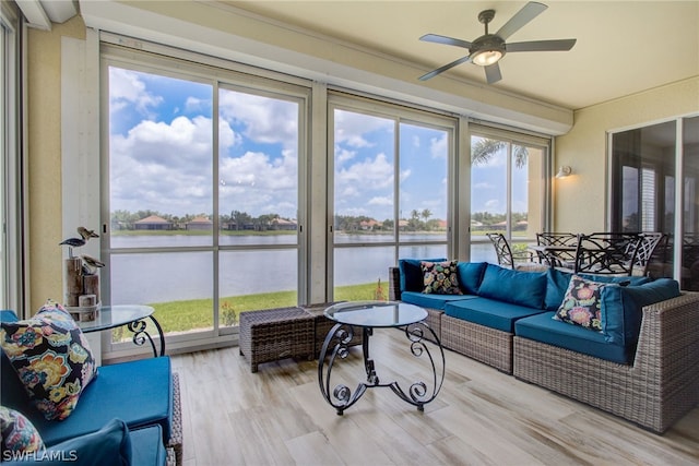 sunroom with a water view, plenty of natural light, and ceiling fan