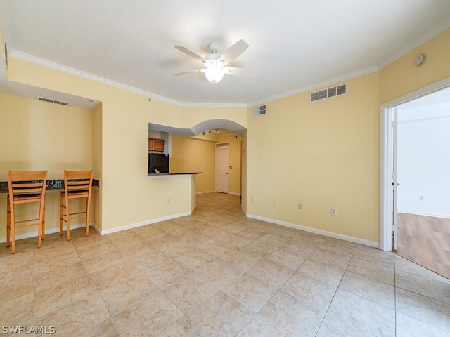 unfurnished room with visible vents, arched walkways, and crown molding