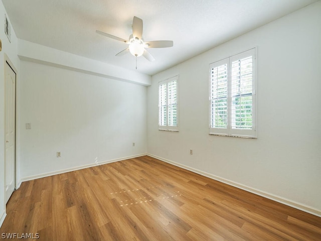 spare room with light wood-style floors, ceiling fan, and baseboards