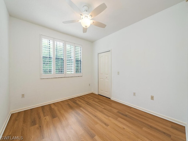 empty room featuring baseboards, ceiling fan, and light wood finished floors