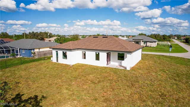 rear view of house featuring a lawn