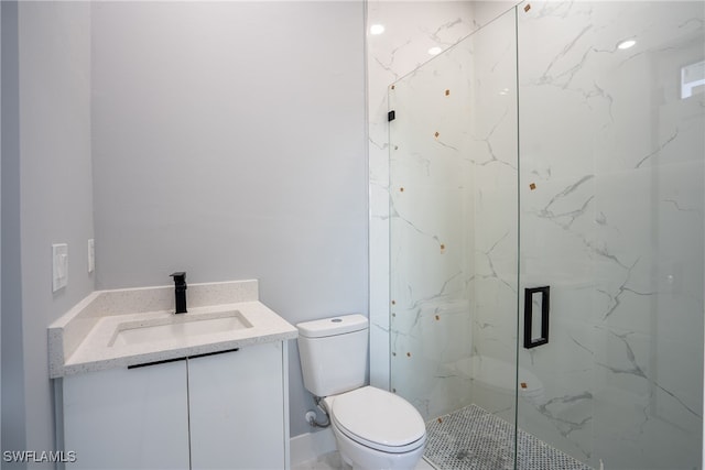 bathroom featuring toilet, an enclosed shower, and vanity