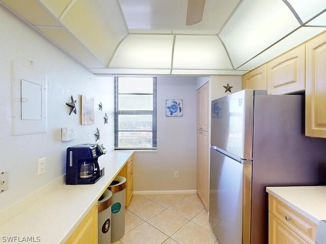 kitchen with light brown cabinets, stainless steel fridge, and light tile floors