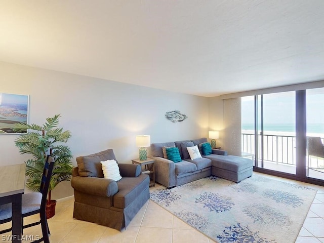 tiled living room with a wall of windows and a water view