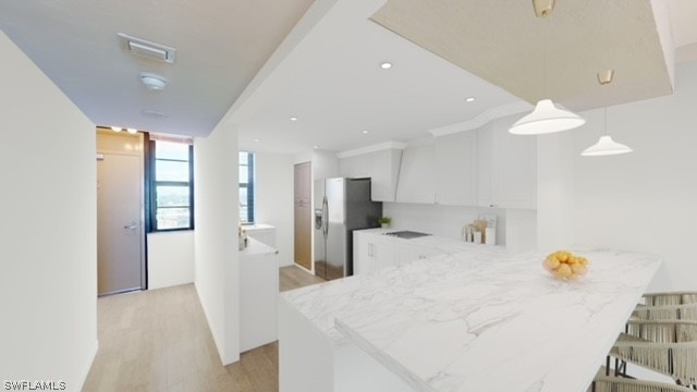 kitchen featuring light hardwood / wood-style floors, kitchen peninsula, decorative light fixtures, stainless steel refrigerator with ice dispenser, and white cabinets