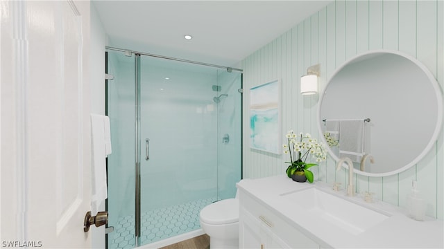 bathroom with an enclosed shower, vanity, and toilet