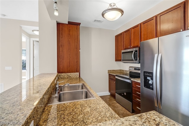 kitchen featuring sink, stainless steel appliances, light stone countertops, and tile flooring