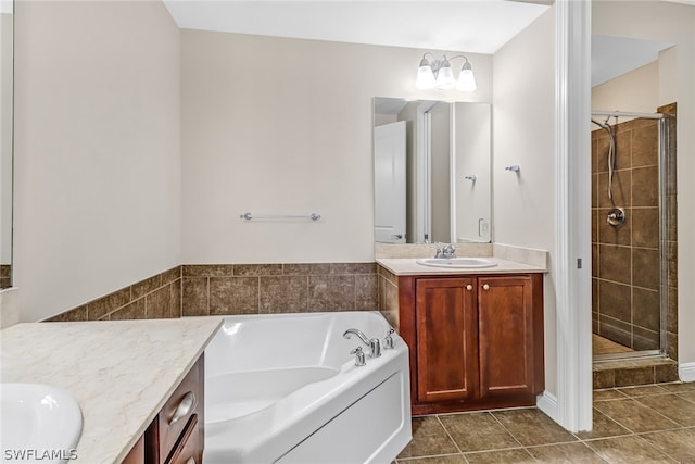 bathroom featuring vanity with extensive cabinet space, shower with separate bathtub, and tile flooring