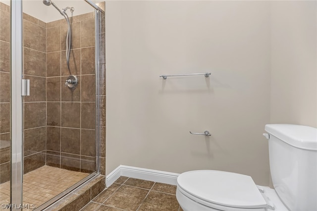 bathroom featuring an enclosed shower, toilet, and tile flooring