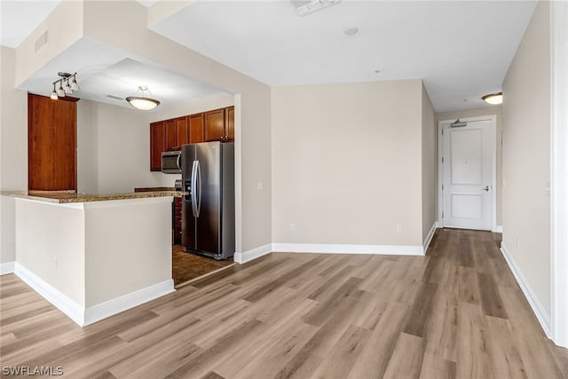 kitchen with light hardwood / wood-style floors, appliances with stainless steel finishes, and kitchen peninsula