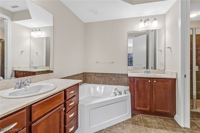 bathroom with tile flooring, a bath to relax in, and dual vanity