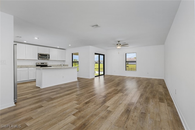 unfurnished living room with ceiling fan and light hardwood / wood-style flooring