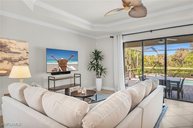 tiled living room featuring crown molding, a tray ceiling, and ceiling fan