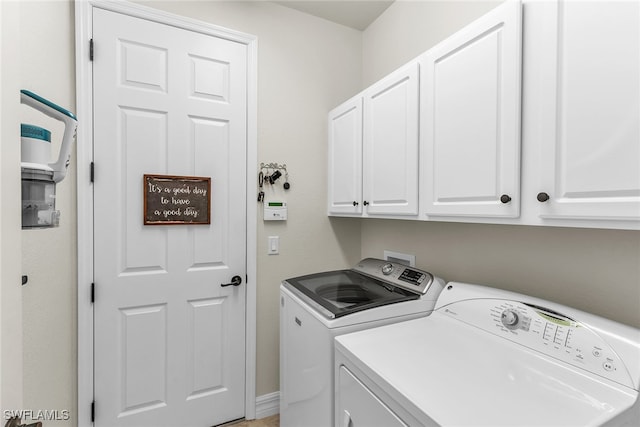 laundry area with cabinets and washer and clothes dryer