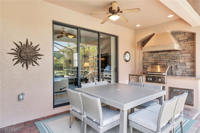 view of patio with area for grilling, ceiling fan, a fireplace, and exterior kitchen