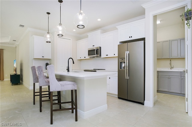 kitchen with a center island with sink, white cabinetry, and appliances with stainless steel finishes