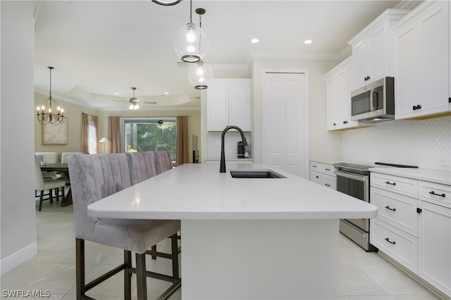 kitchen featuring sink, stainless steel appliances, white cabinetry, and a center island with sink