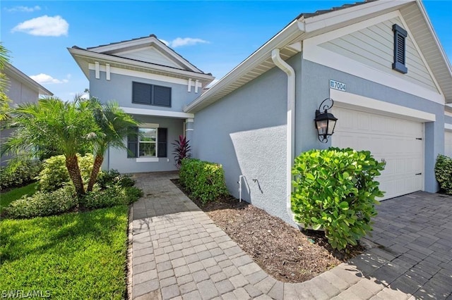 view of front of home featuring stucco siding, driveway, and an attached garage
