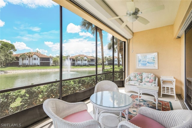 sunroom with a water view, ceiling fan, and a wealth of natural light