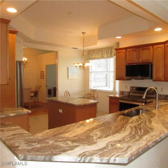 kitchen with sink, an inviting chandelier, appliances with stainless steel finishes, kitchen peninsula, and pendant lighting