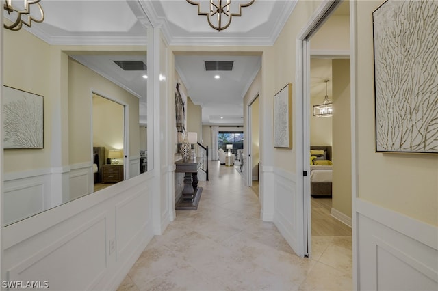 hallway with crown molding and a chandelier