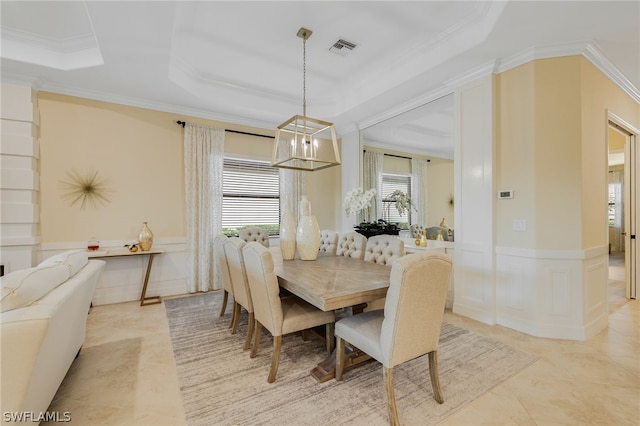 dining room featuring a chandelier, a tray ceiling, and crown molding