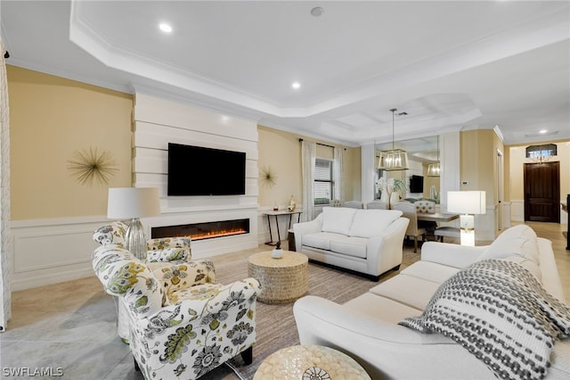 living room featuring a raised ceiling and ornamental molding