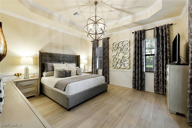 bedroom with a raised ceiling, crown molding, wood-type flooring, and a notable chandelier