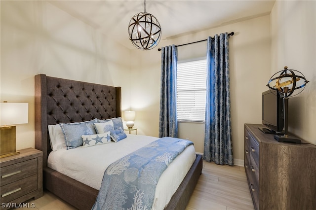 bedroom with a notable chandelier and light wood-type flooring