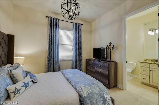 bedroom with light tile patterned floors, connected bathroom, and a chandelier