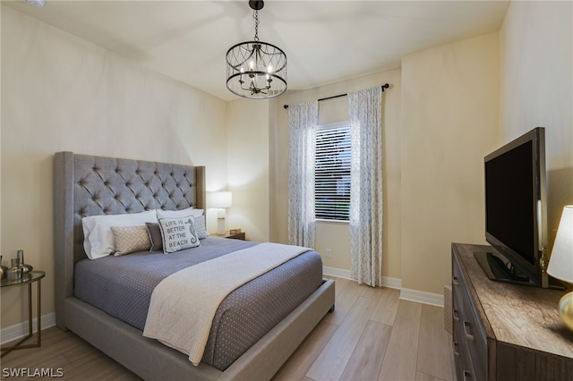 bedroom featuring light hardwood / wood-style floors and a chandelier