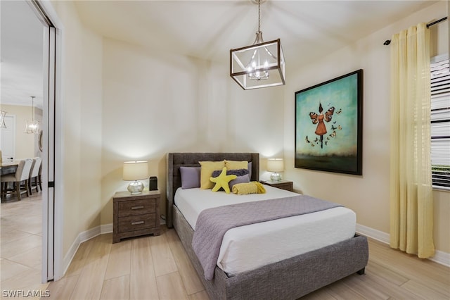 bedroom featuring a chandelier and light hardwood / wood-style floors