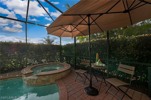 view of patio featuring glass enclosure and a swimming pool with hot tub