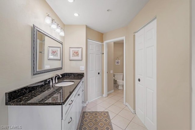 bathroom with vanity, toilet, and tile flooring