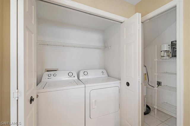 laundry area with light tile floors and washing machine and clothes dryer