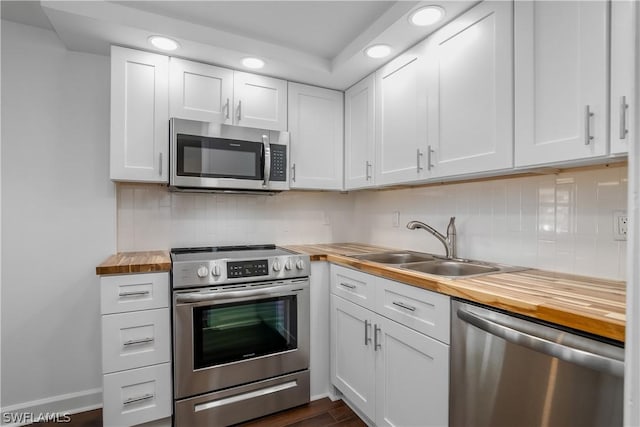 kitchen featuring wood counters, white cabinets, sink, dark hardwood / wood-style floors, and stainless steel appliances