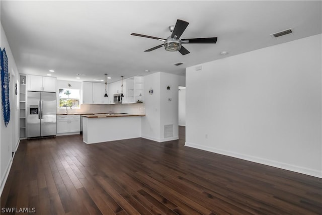 unfurnished living room with dark hardwood / wood-style floors, ceiling fan, and sink