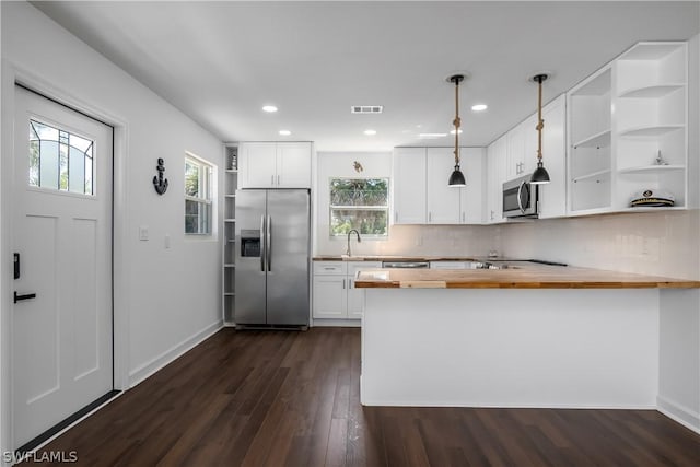 kitchen featuring pendant lighting, white cabinets, butcher block countertops, kitchen peninsula, and stainless steel appliances