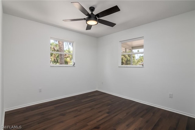 unfurnished room with plenty of natural light, dark wood-type flooring, and ceiling fan